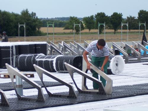 Man installs solar base frames on a green roof